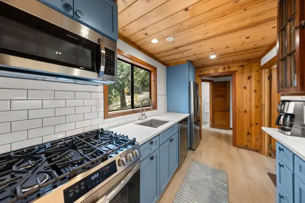 Kitchen with blue cabinets, gas range and subway tile, Homewood Cabin in the Pines