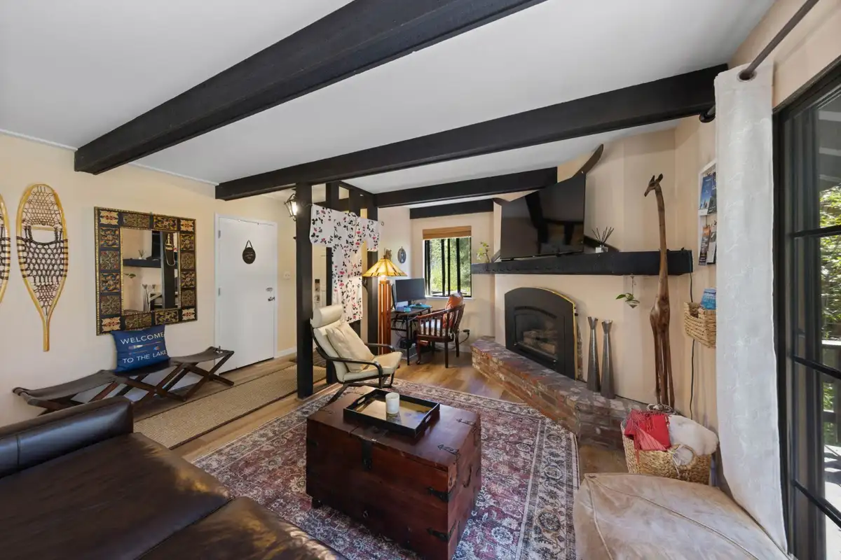 Living room with a fireplace, beamed ceiling and trunk table, Cortina Chalet