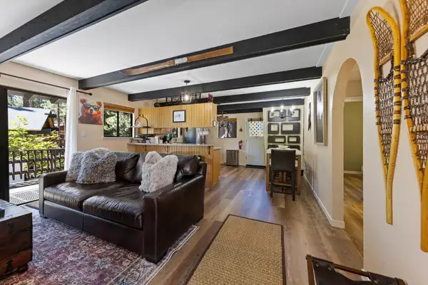 Living room with a leather sofa, beamed ceiling and snowshoes on the wall, Cortina Chalet