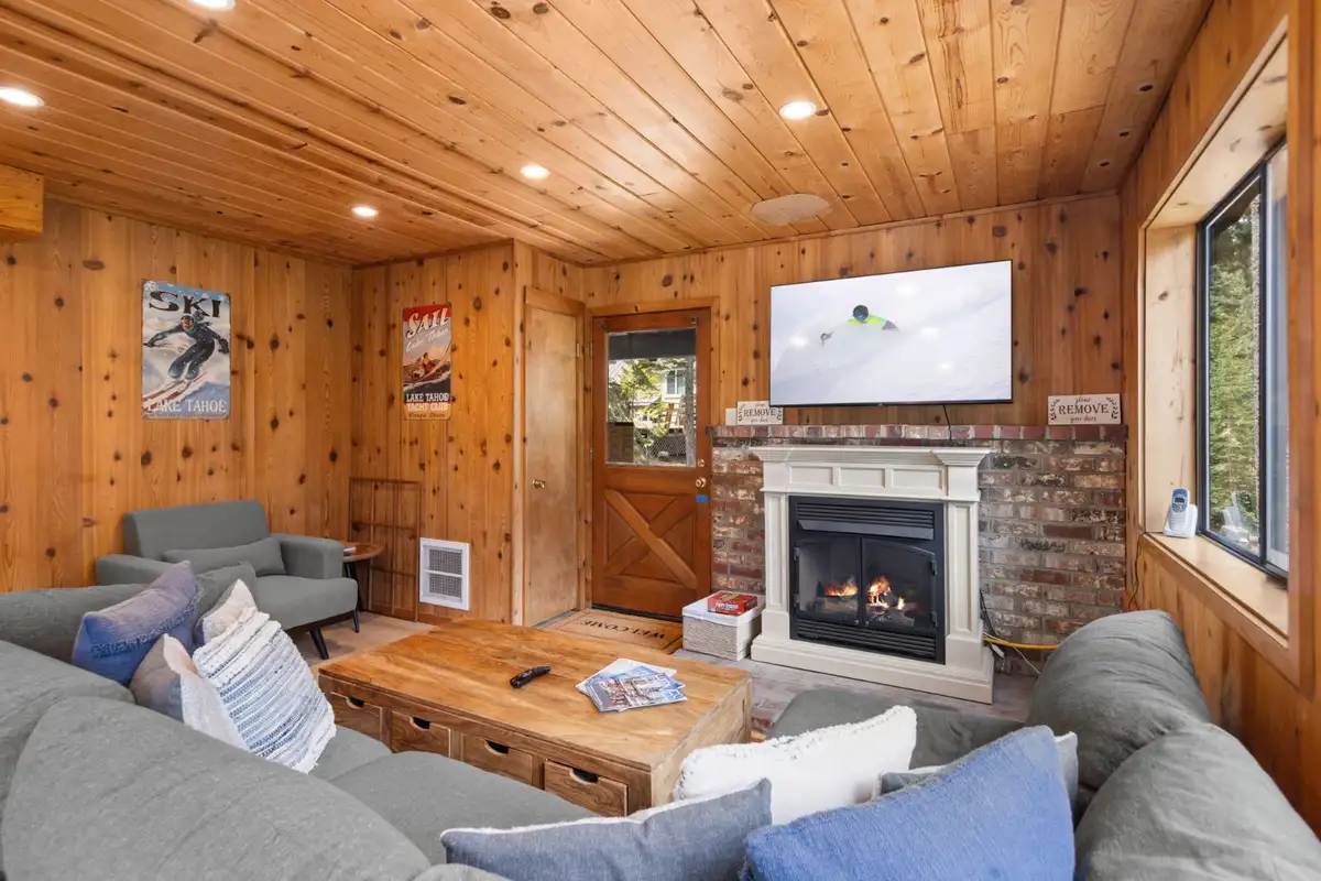 Living room with a sectional, fireplace and wall TV, Homewood Cabin in the Pines