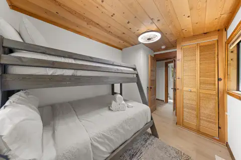 Gray bunk bed beside louvered closet doors, Homewood Cabin in the Pines