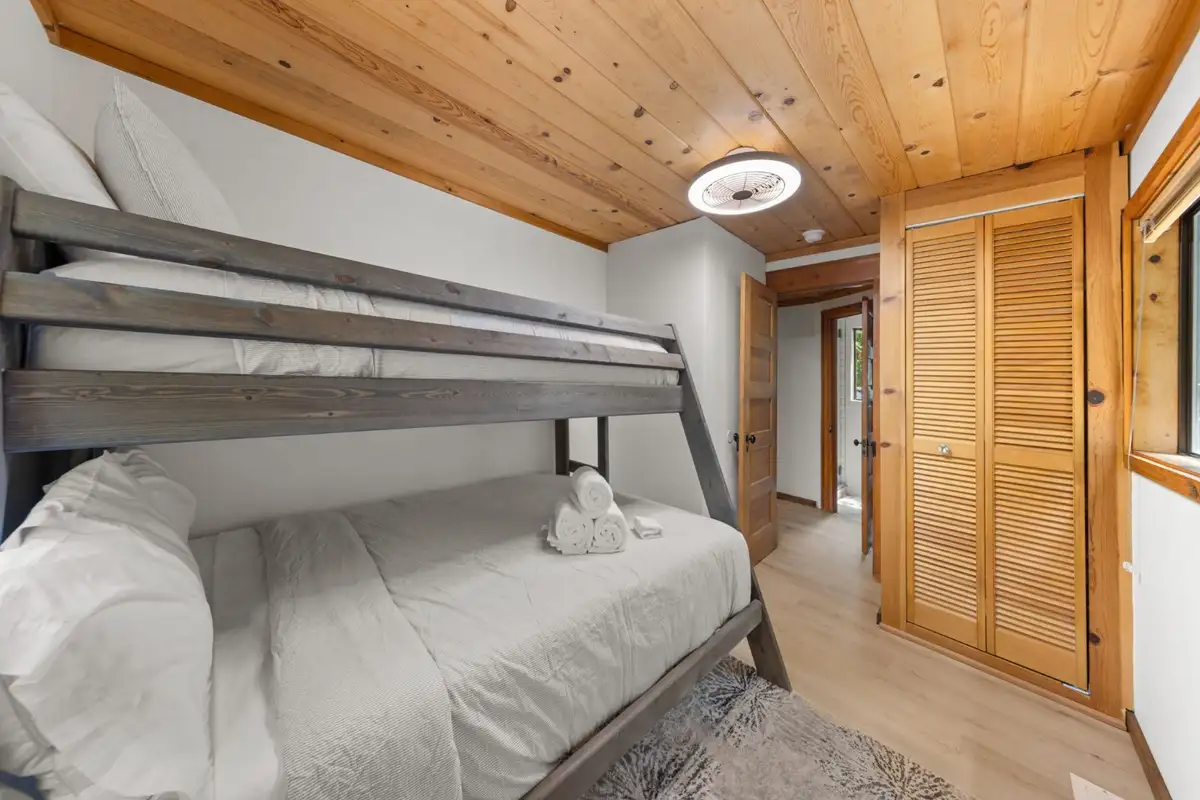 Gray bunk bed beside louvered closet doors, Homewood Cabin in the Pines