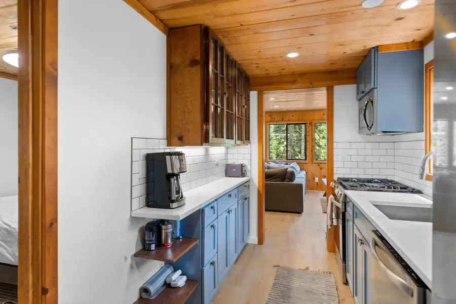Galley kitchen with blue cabinets and pine ceiling, Homewood Cabin in the Pines