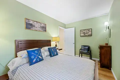Green bedroom with a bed and compass pillow, Cortina Chalet