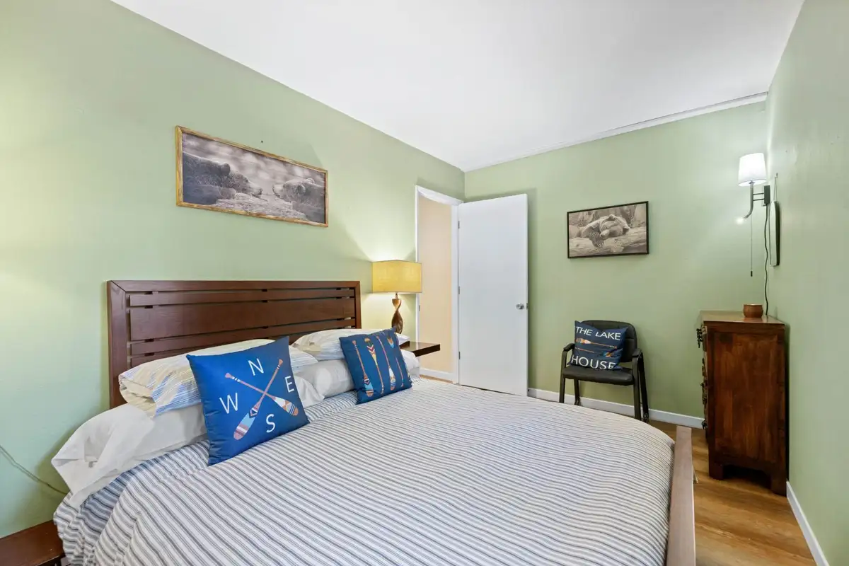 Green bedroom with a bed and compass pillow, Cortina Chalet