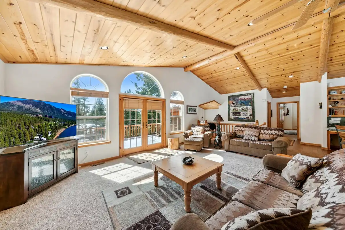 Living room with wood ceiling, arched windows and leather sofas, Hastings Hideaway Cabin