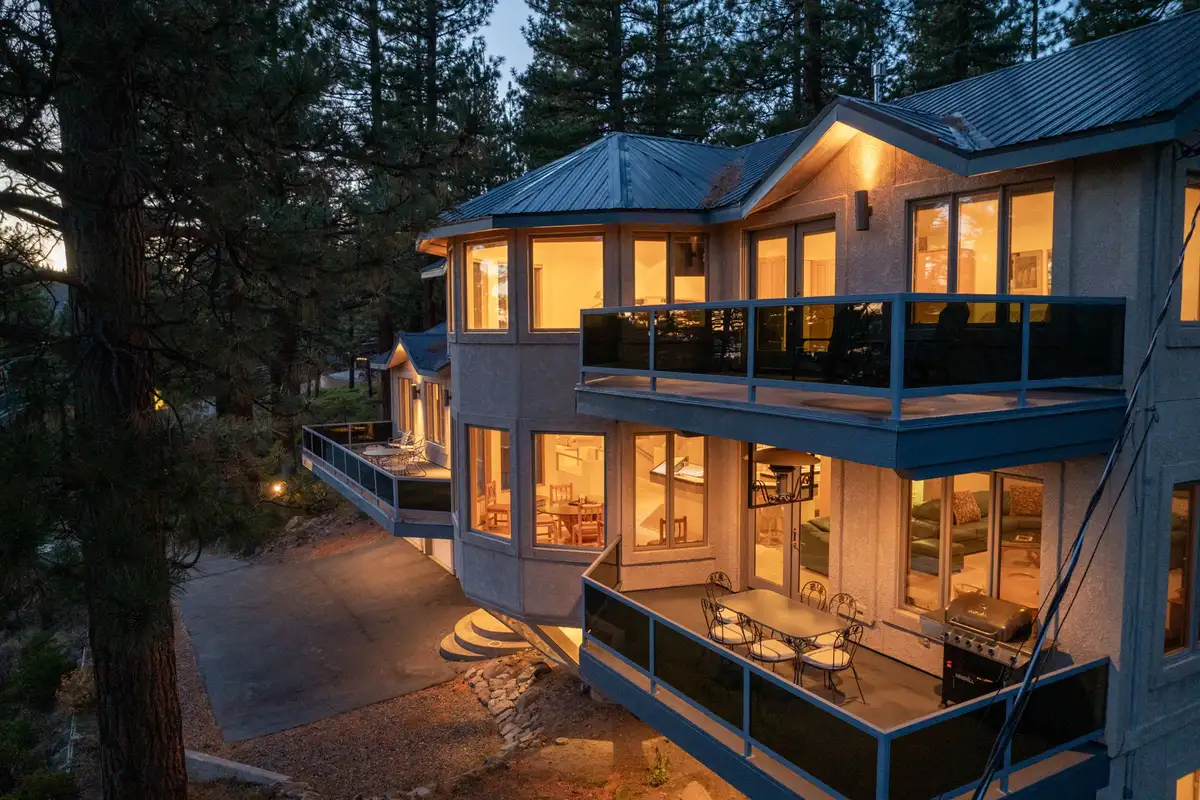 Multi-level home with lit windows and balconies at dusk, 90s Tahoe Time Capsule