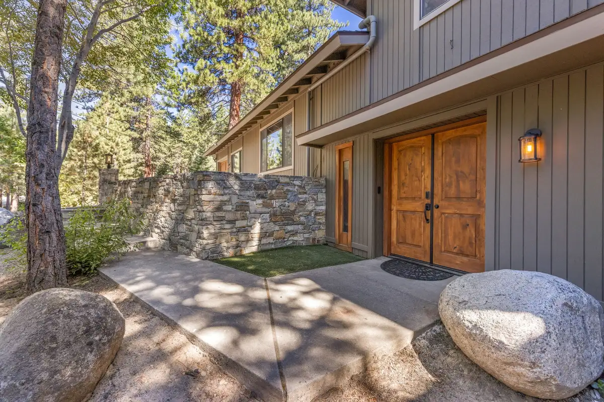 Front entrance with double wood doors and a stone wall, Tranquil Stay