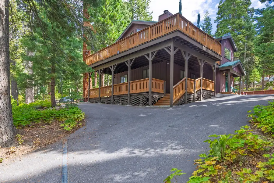 Two-story wood home with wraparound deck in the forest, Evergreen Hideout