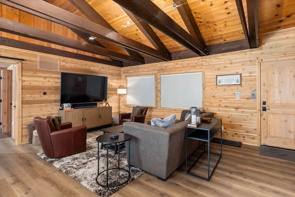 Living room with wood walls, leather chairs and wall-mounted TV, Updated West Shore Cabin 1 mile to Chambers Beach