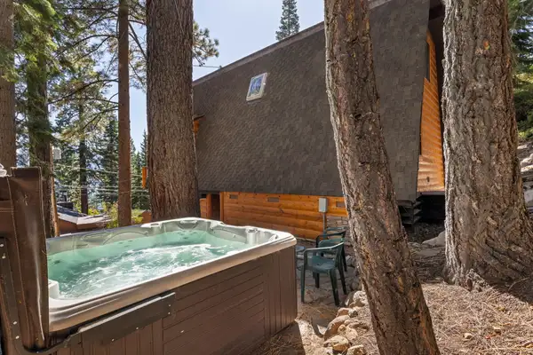 Hot tub beside an A-frame cabin among pines, Livin' on the Edge