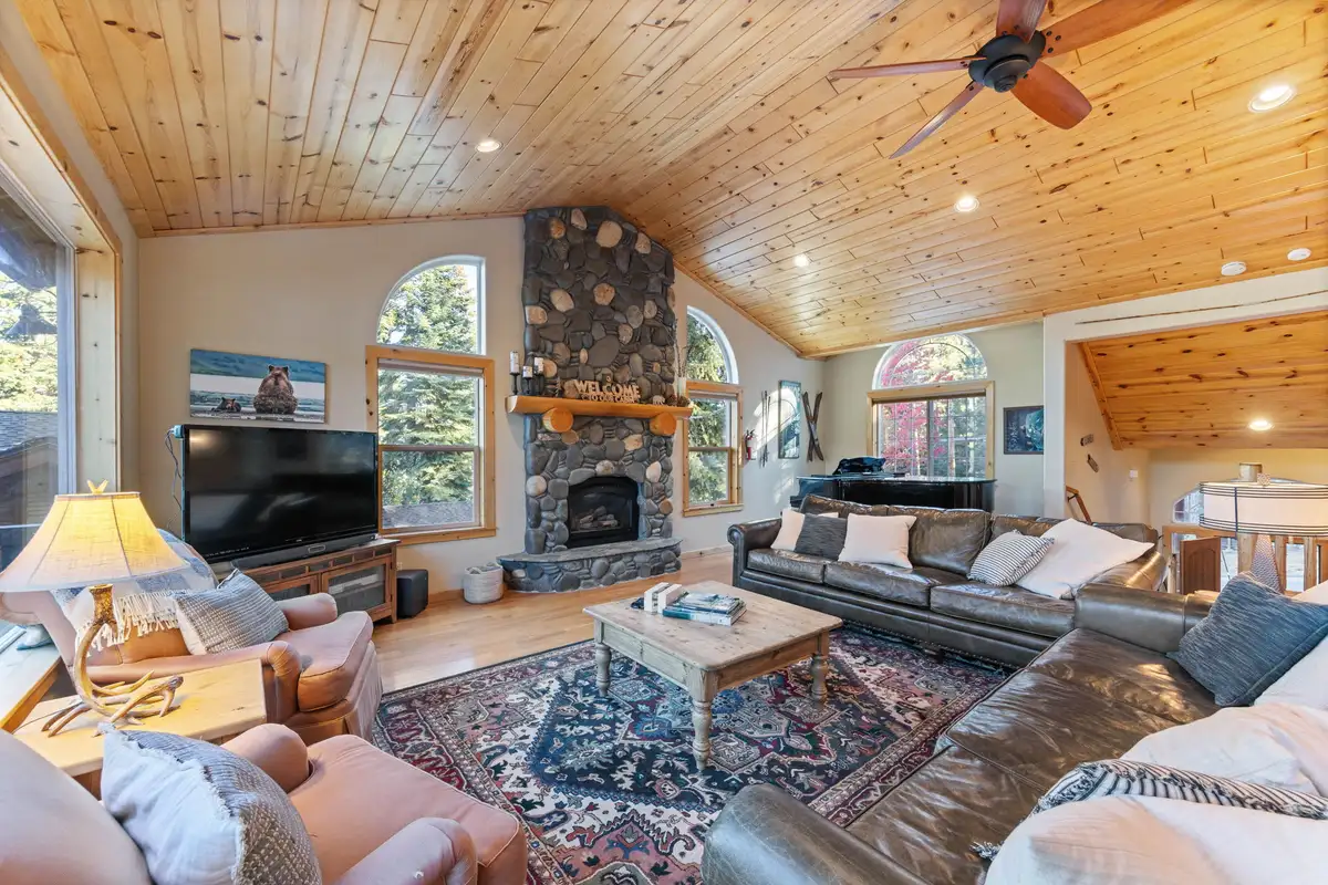 Living room with stone fireplace and leather sofas, Lakeview Grandeur