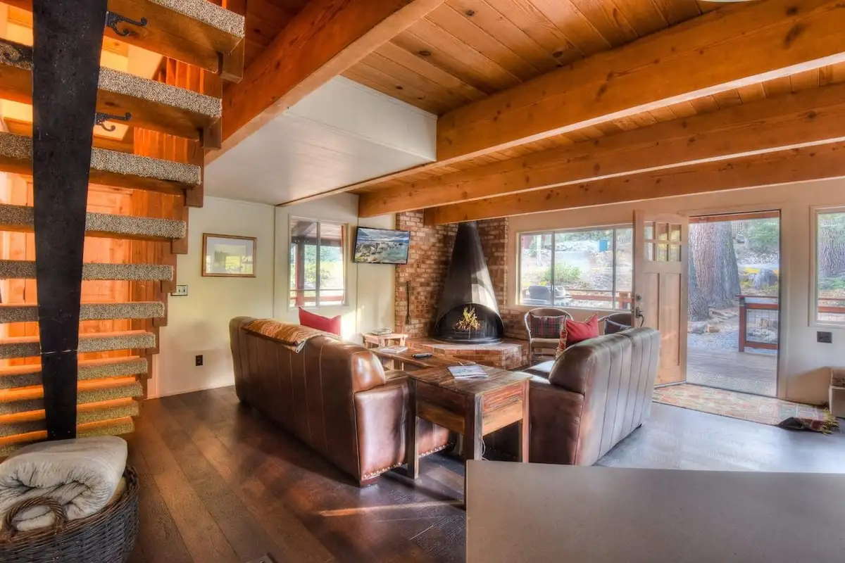 Living room with an open-tread staircase and leather sofas, Enchanting Chamberlands Cabin