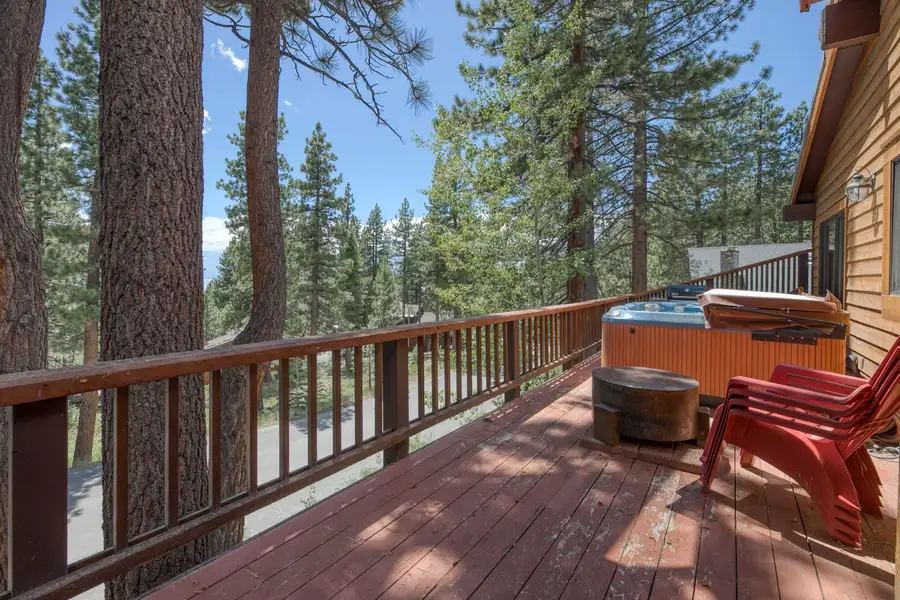 Deck with a hot tub and red chairs among pines, Lunar Lakeview Haven