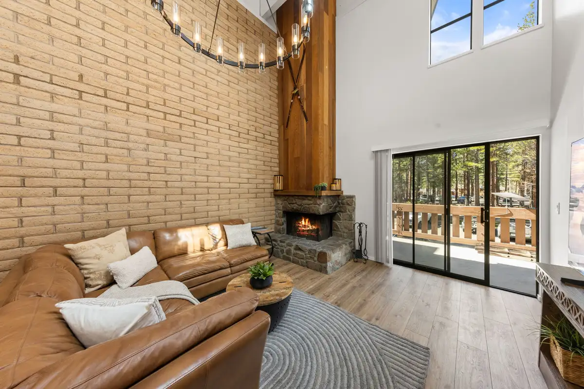 Cozy stone fireplace with leather sectional and sliding doors to balcony, Treetop on Country Club