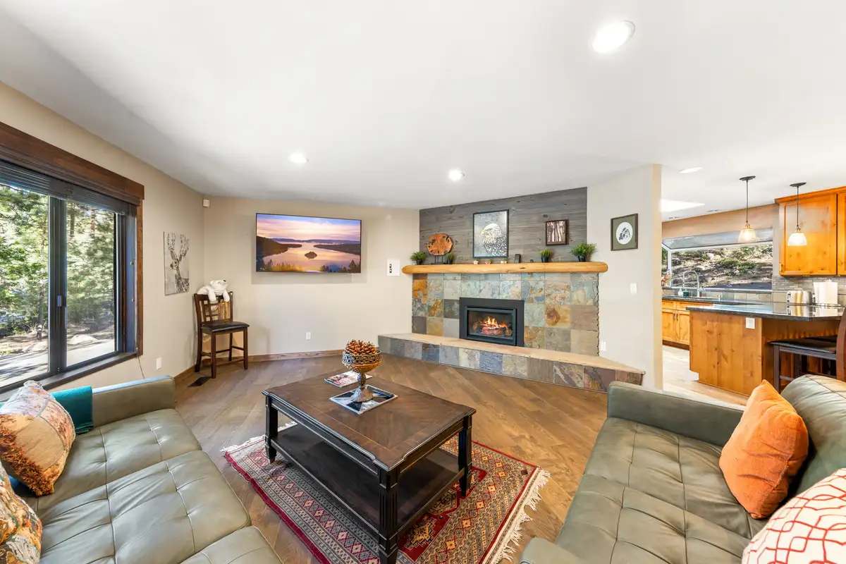 Living room with a tiled fireplace, leather sofas and wall TV, Tranquil Stay