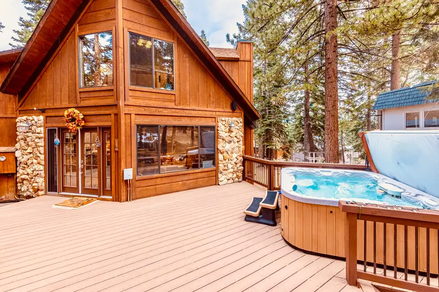 Deck with an open hot tub beside a wood A-frame, Sunlit Incline Retreat