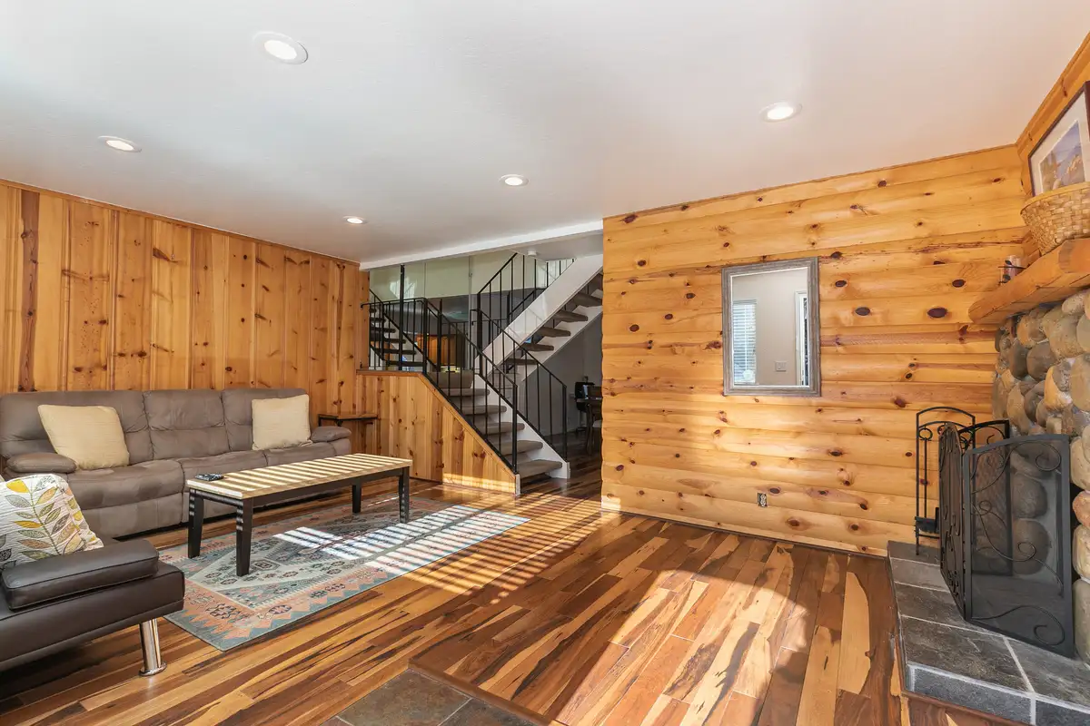 Living room with wood-paneled walls and open staircase, Trailside Tahoe Townhouse