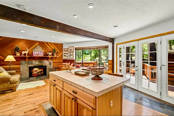 Kitchen island facing a fireplace and French doors, Sunlit Incline Retreat