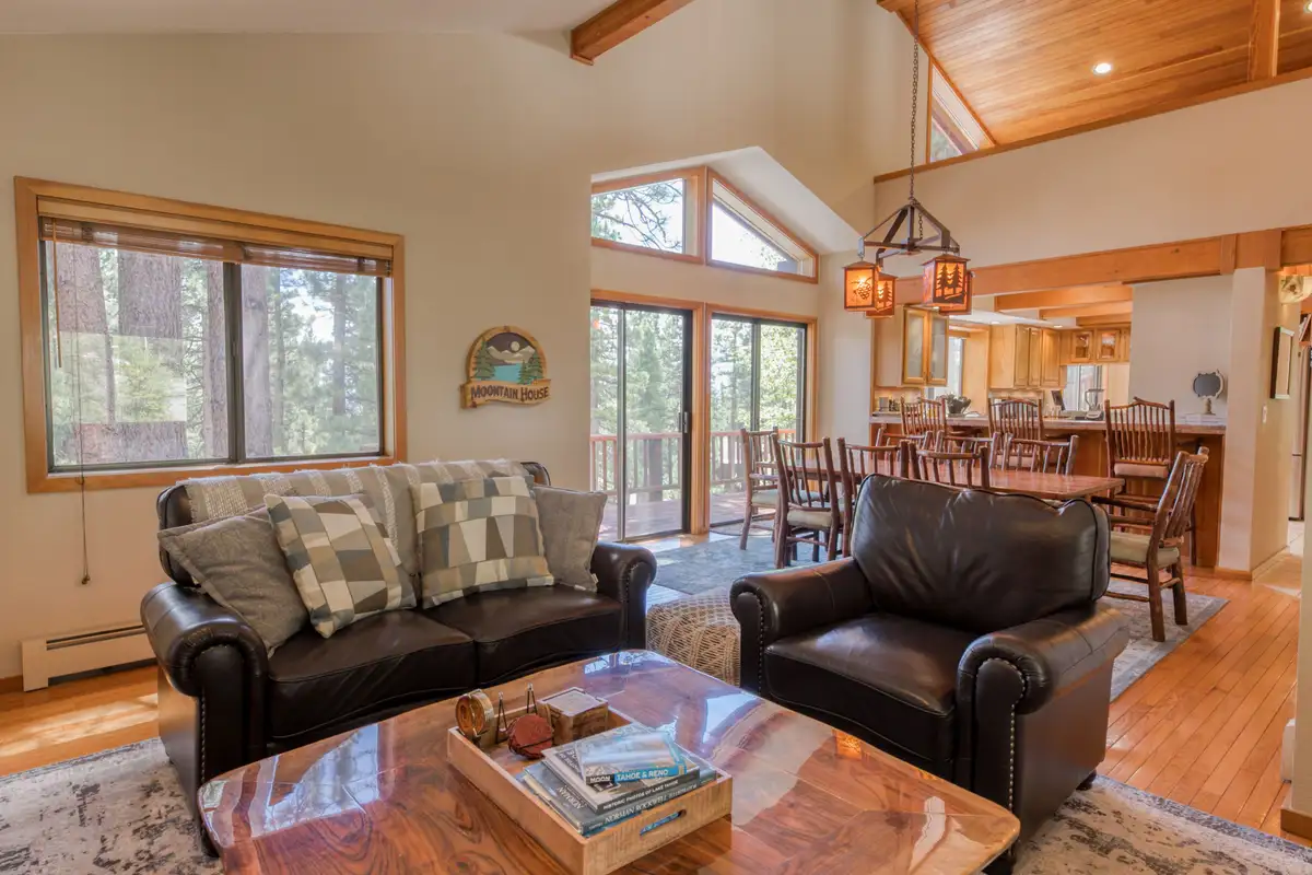 Living room with leather seating and dining area beyond, Lunar Lakeview Haven