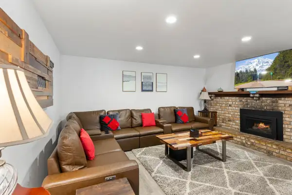Living room with a leather sectional and brick fireplace, Tahoe Lake & Mountain Retreat
