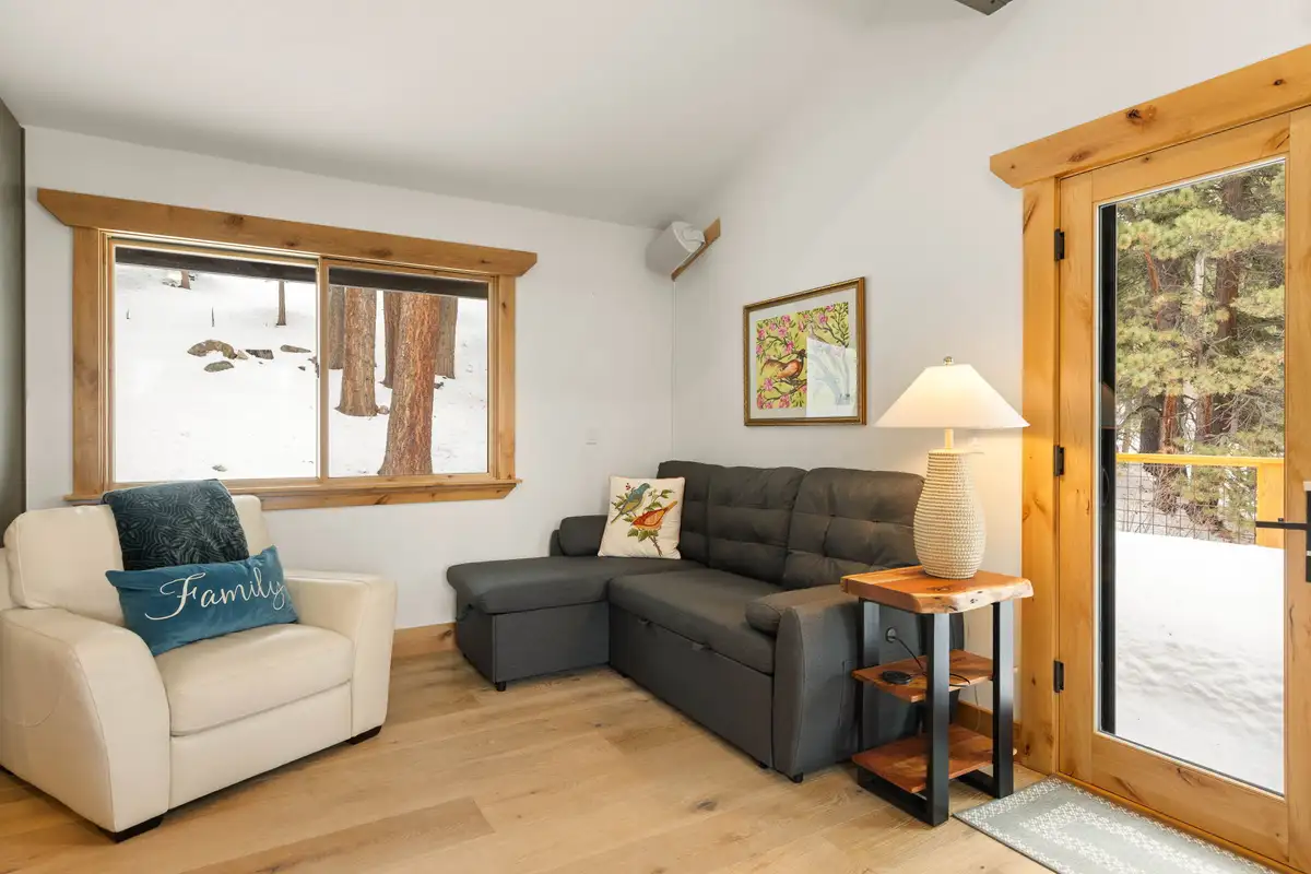 Living area with armchair, sleeper sofa and snowy window view, Sugar Pine Tahoe Lodge