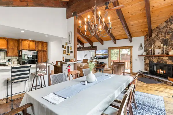 Dining table with chandelier and stone fireplace, Evergreen Hideout