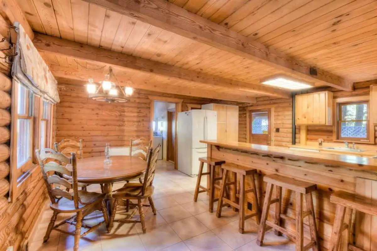 Round dining table near a breakfast bar in a log cabin, Enchanted Woods Cabin