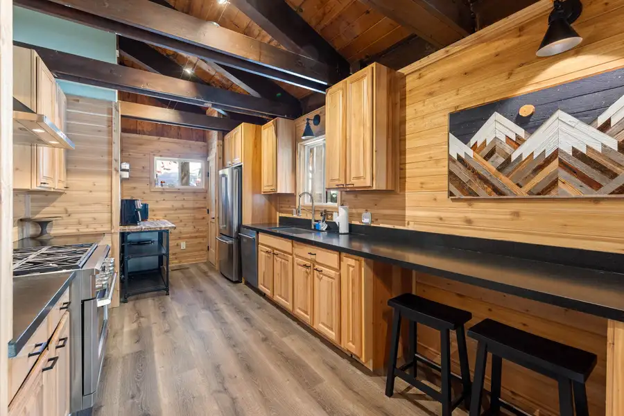 Kitchen with wood cabinets and breakfast bar with stools, Updated West Shore Cabin 1 mile to Chambers Beach