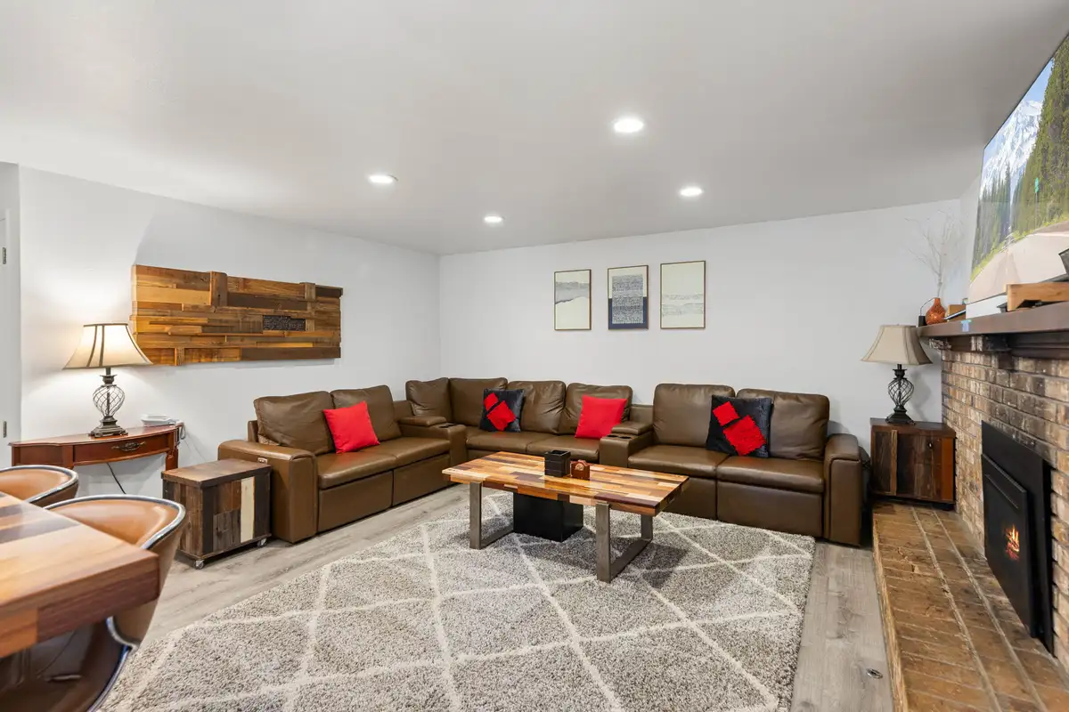 Living room with a leather sectional, brick fireplace and wall TV, Tahoe Lake & Mountain Retreat