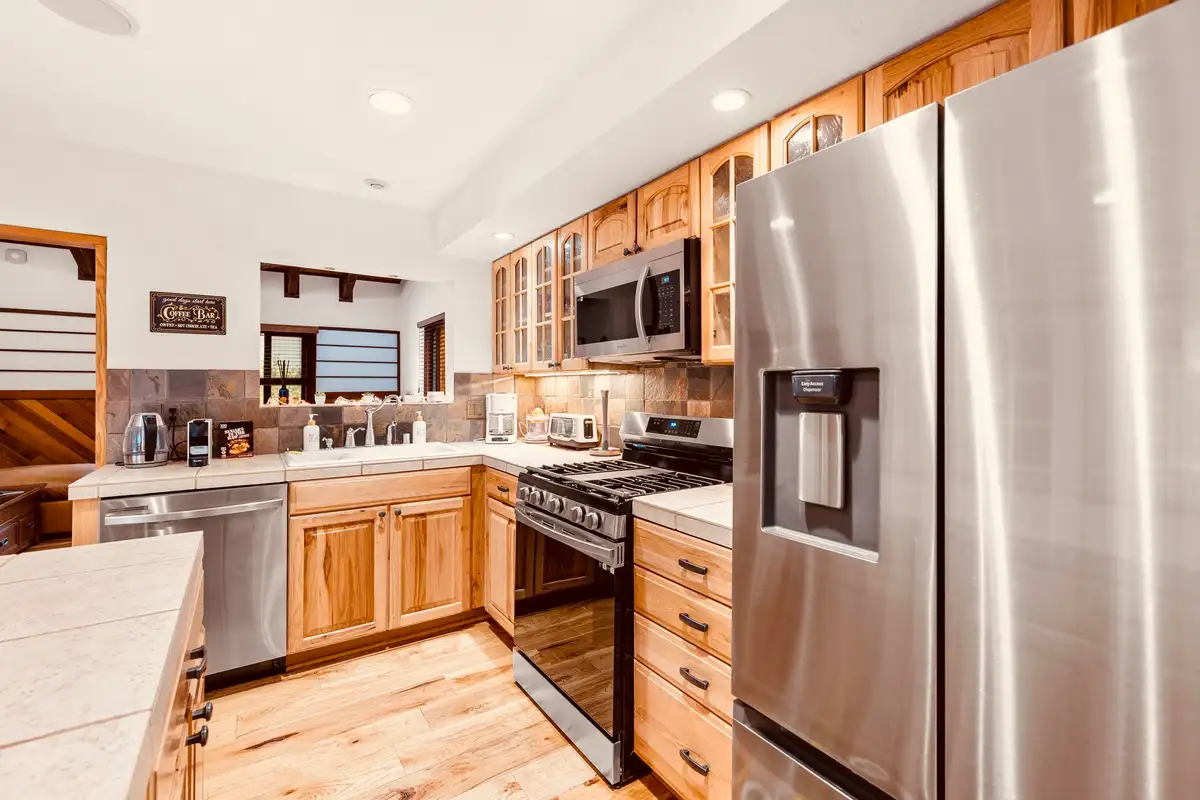 Kitchen with stainless refrigerator and gas range, Sunlit Incline Retreat