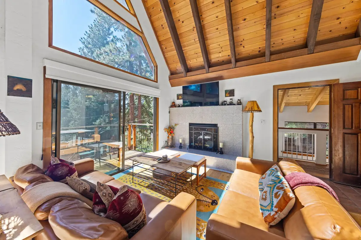 Living room with leather sofas, fireplace and tall windows, Rustic Ridge Retreat