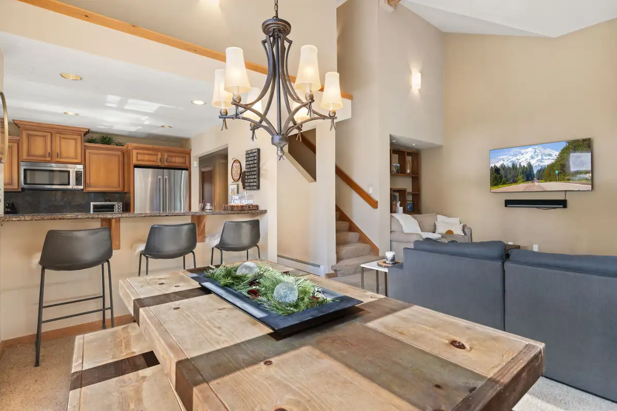 Dining table under a chandelier with kitchen beyond, Elevated Tahoe Escape