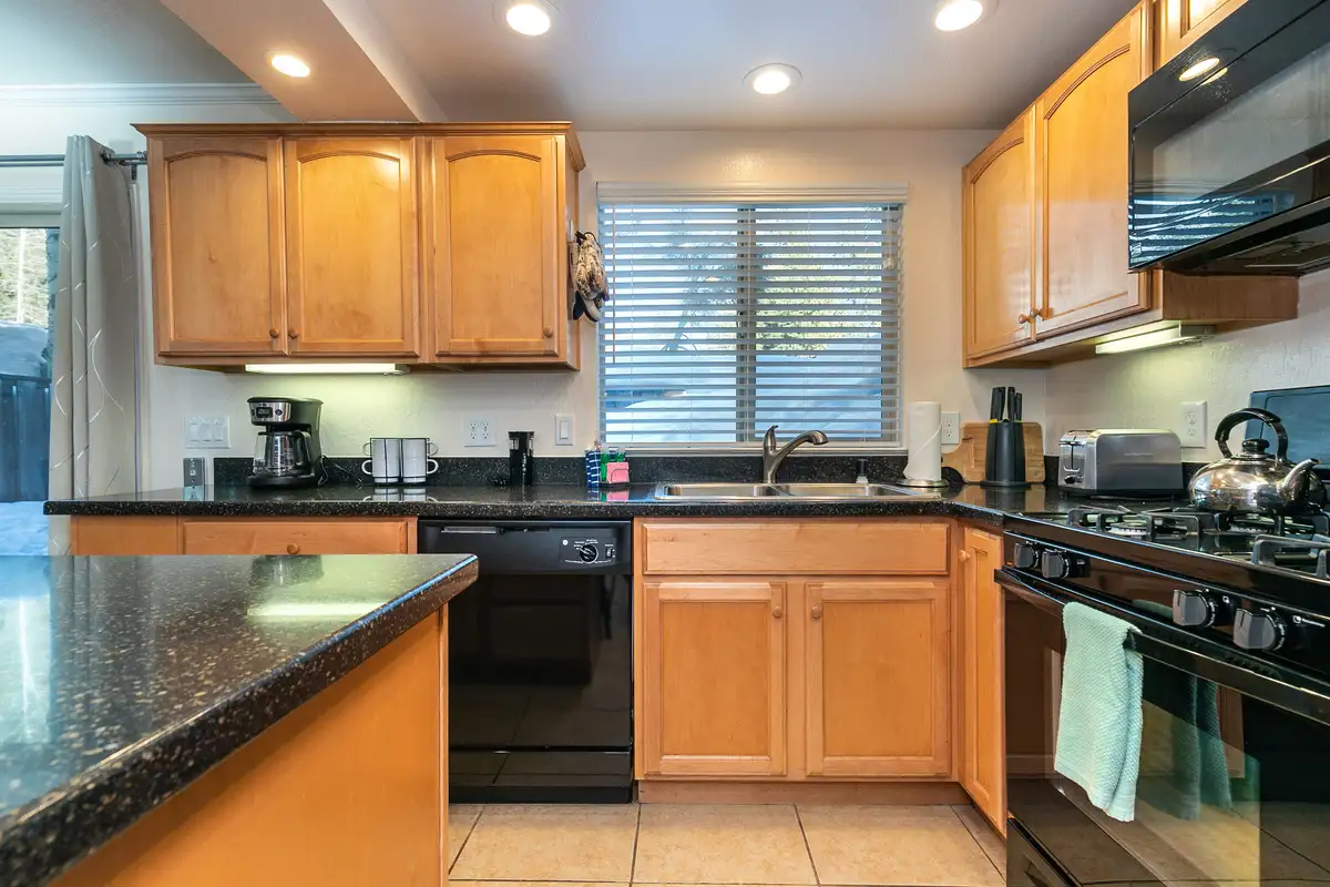 Kitchen with wood cabinets and black appliances, Trailside Tahoe Townhouse
