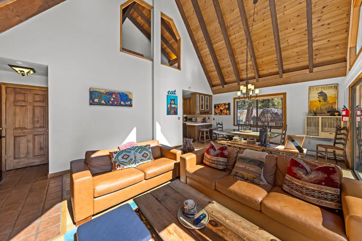 Living room with leather sofas under a vaulted wood ceiling, Rustic Ridge Retreat