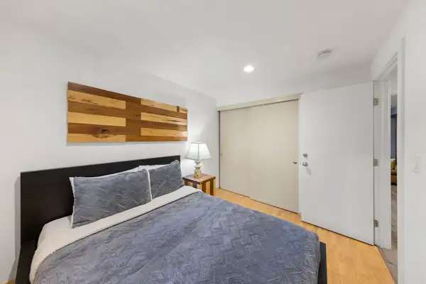Bedroom with a bed, gray bedding and wood wall art, Tahoe Lake & Mountain Retreat