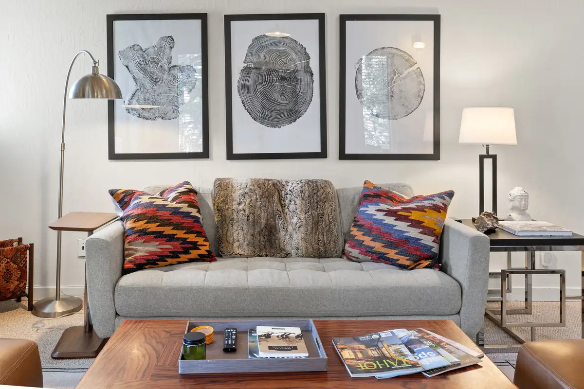 Living area with a gray sofa and framed tree-ring art, Serenity Bungalow
