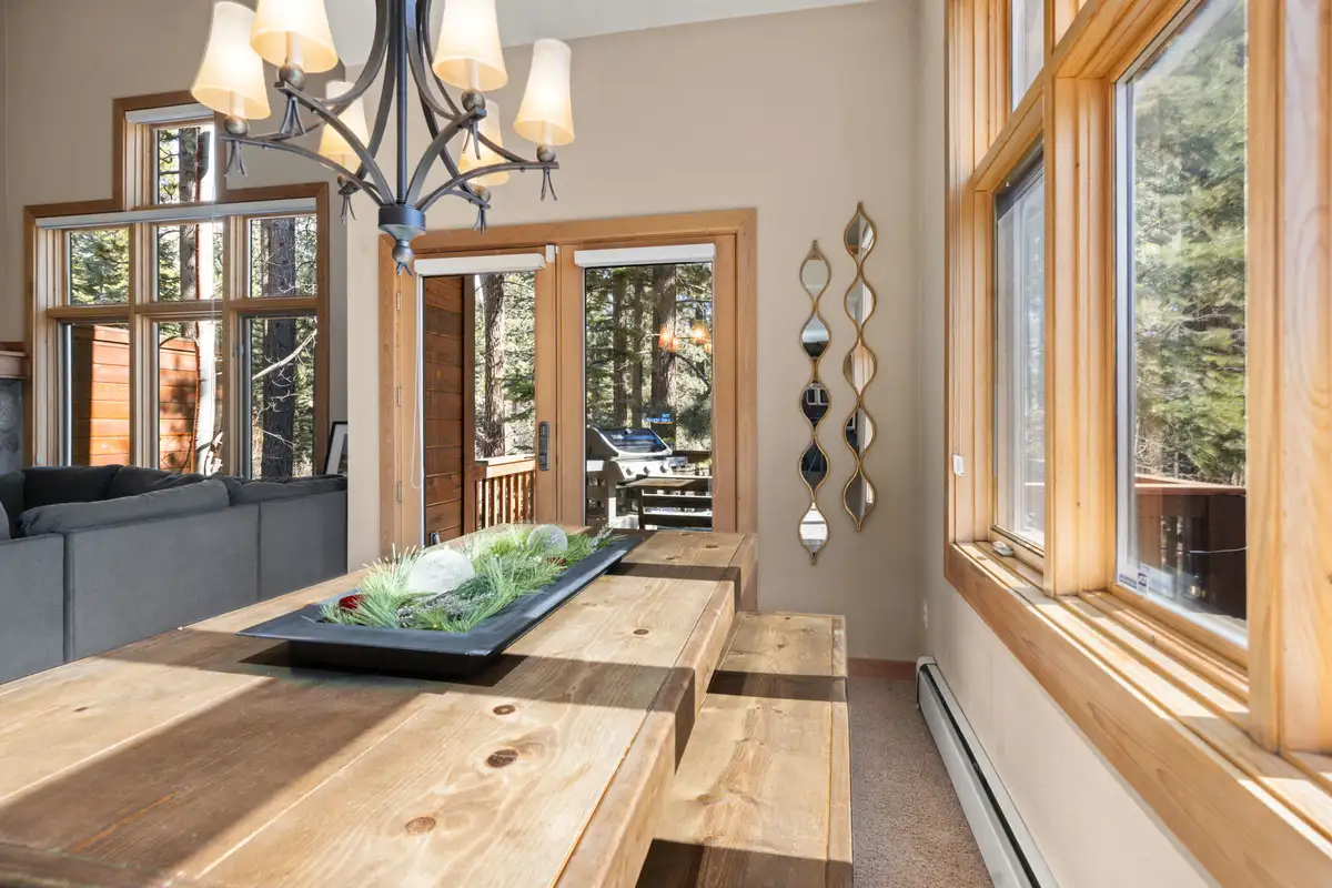 Dining table by tall windows under a chandelier, Elevated Tahoe Escape