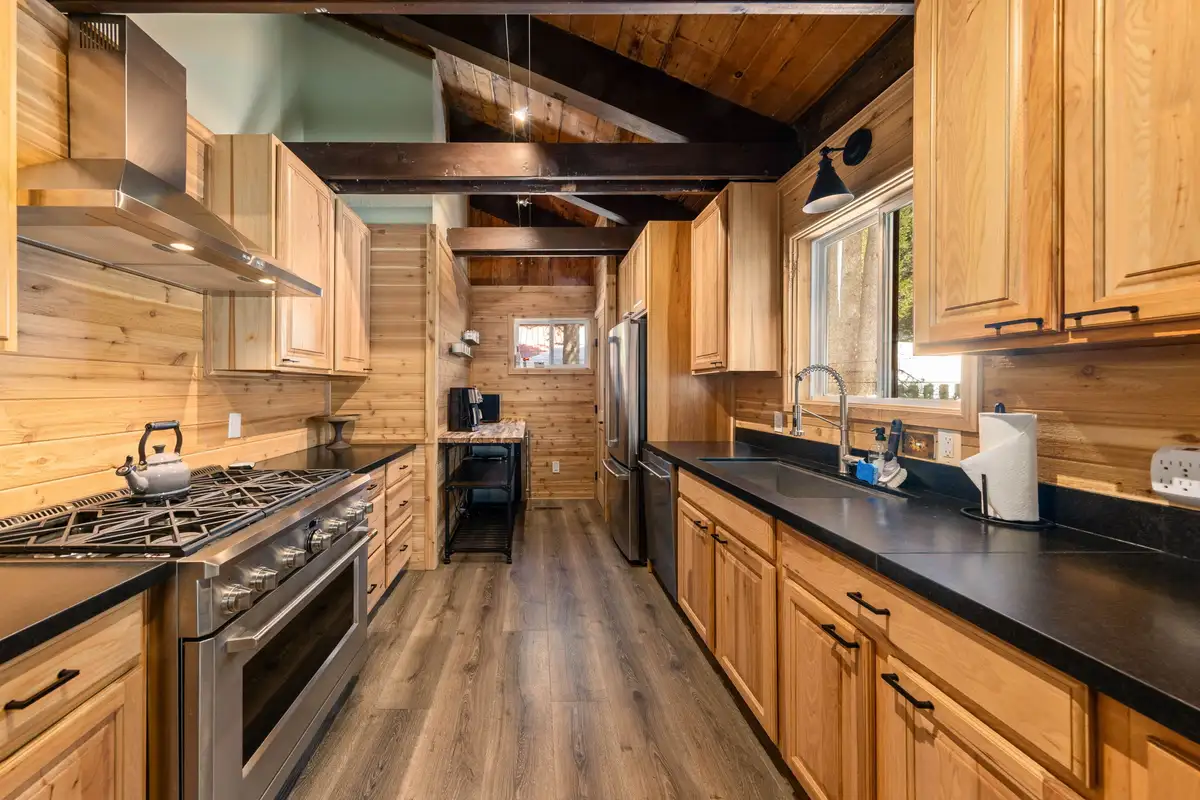 Galley kitchen with wood cabinets and black counters, Updated West Shore Cabin 1 mile to Chambers Beach