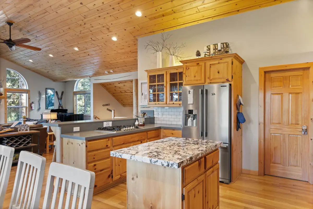 Kitchen with granite island and stainless refrigerator, Lakeview Grandeur
