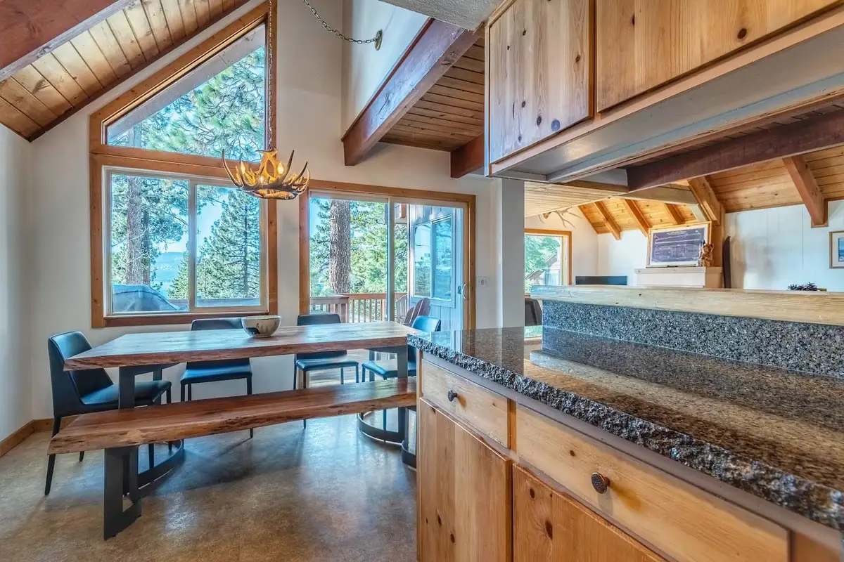 Dining table with bench beside tall windows, Lakeview Serenity Cottage