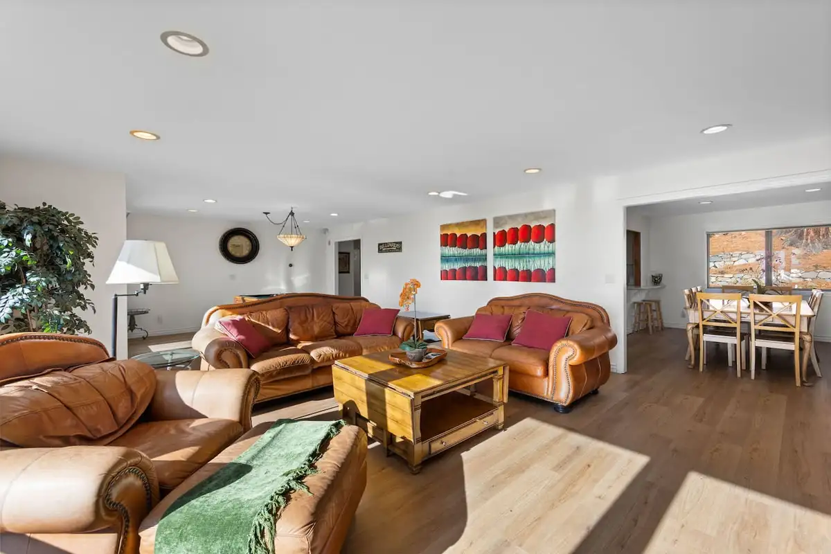 Living room with leather sofas and dining area beyond, Tranquil Alpine Bliss