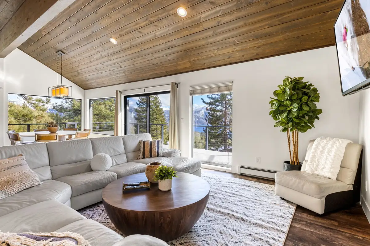 Living room with white sectional and lake visible through windows, Incline Lakehouse Lookout