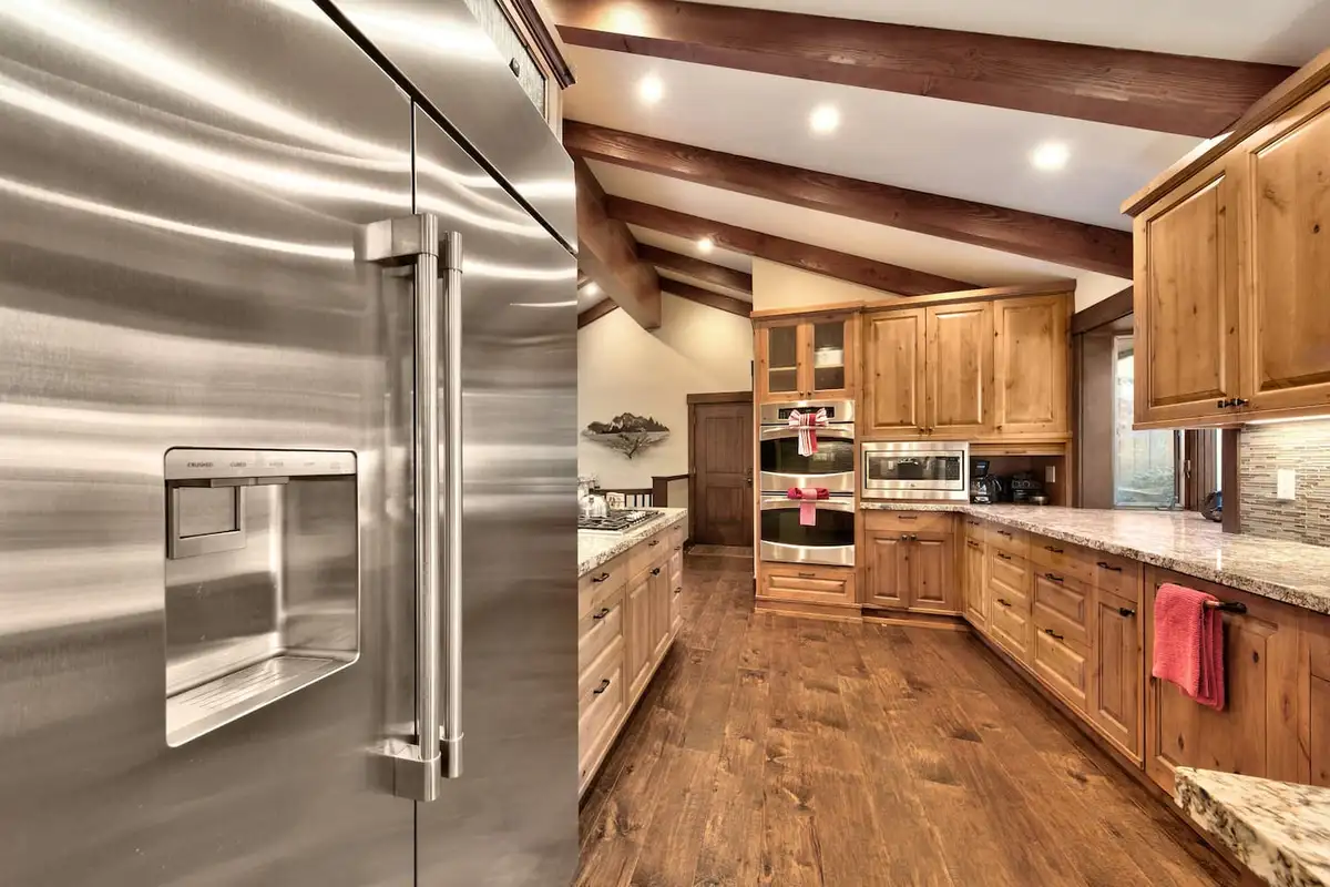 Kitchen with a large stainless refrigerator and wood cabinets, Mammoth Haven Retreat