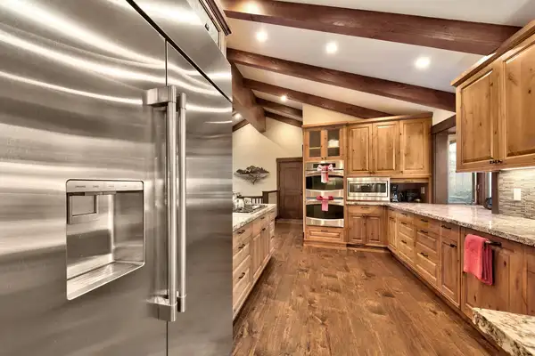 Kitchen with a large stainless refrigerator and wood cabinets, Mammoth Haven Retreat