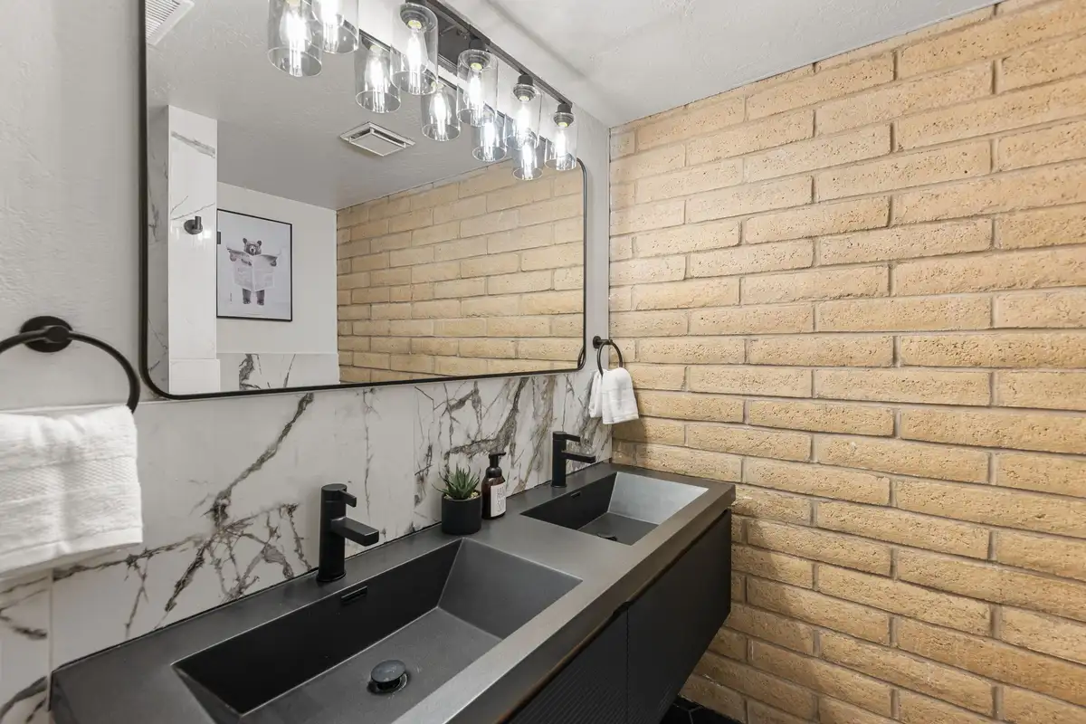 Main bathroom double vanity with black fixtures and marble backsplash, Treetop on Country Club