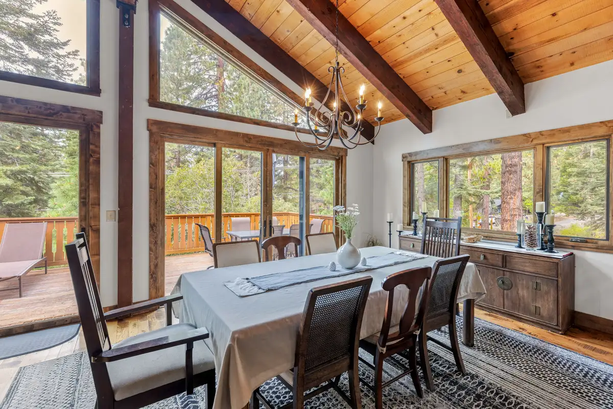 Dining table under a chandelier with tall windows, Evergreen Hideout