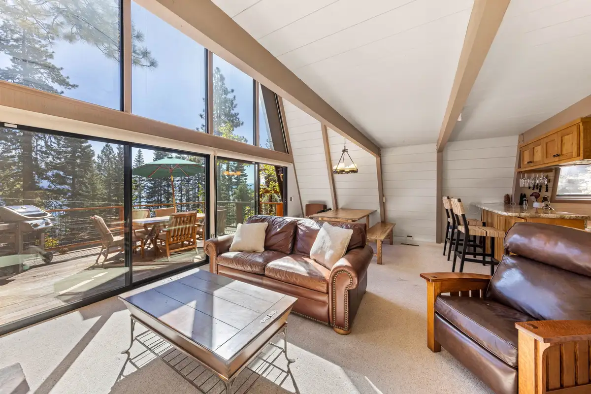Living room with leather sofas and lake view windows, Livin' on the Edge