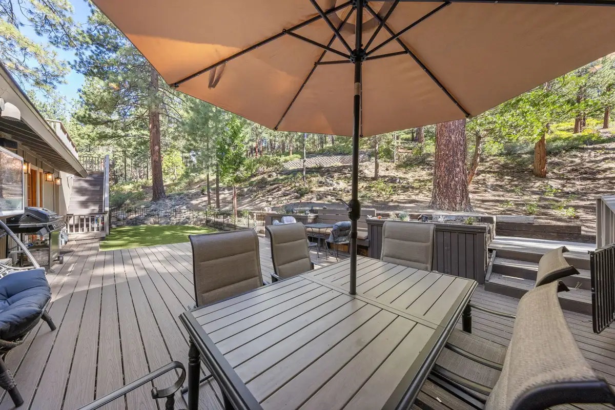 Deck with a dining table and umbrella among pines, Tranquil Stay