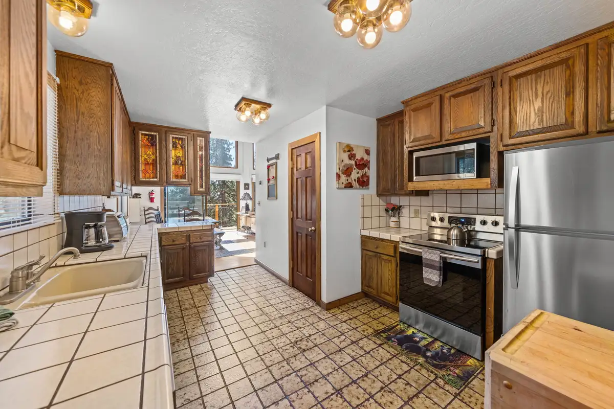 Galley kitchen with wood cabinets and stainless appliances, Rustic Ridge Retreat
